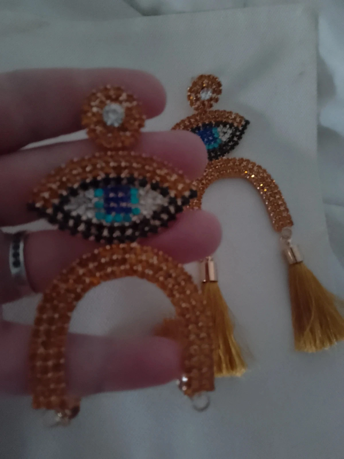 Brincos de olho cigano, strass e pompons – photo 2